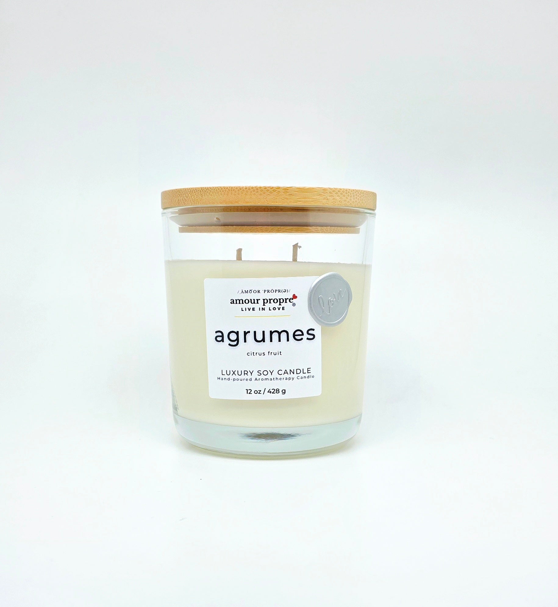 Candle with a wooden lid labeled 'agrumes' on a white background