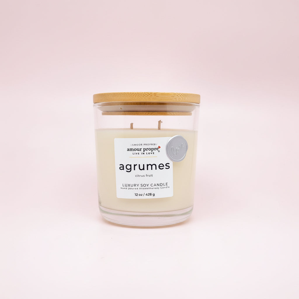 Candle with a wooden lid labeled 'agrumes' on a white background